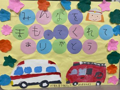 園児が作成した救急車と消防車、消防士の切り絵のメッセージボード
